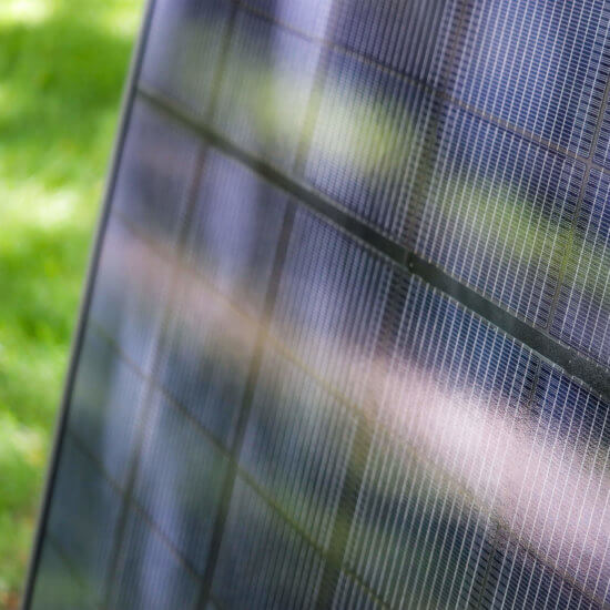 Upclose view of a solar panel used at a Blue Raven Solar installation with green leaves in the background