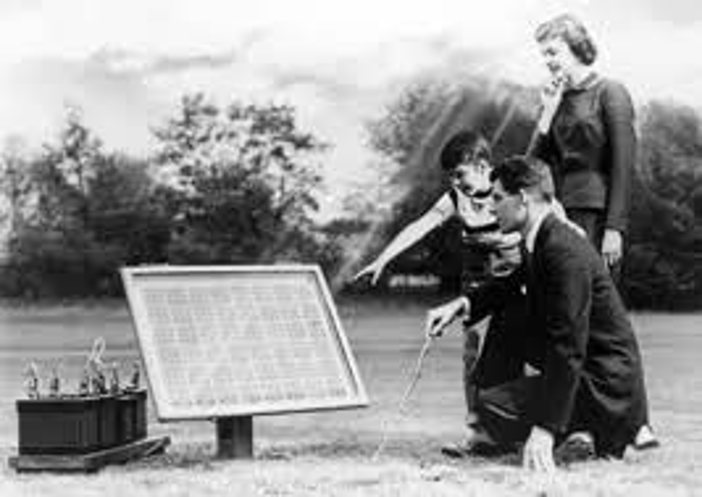 Black and White photo of people looking at solar panel