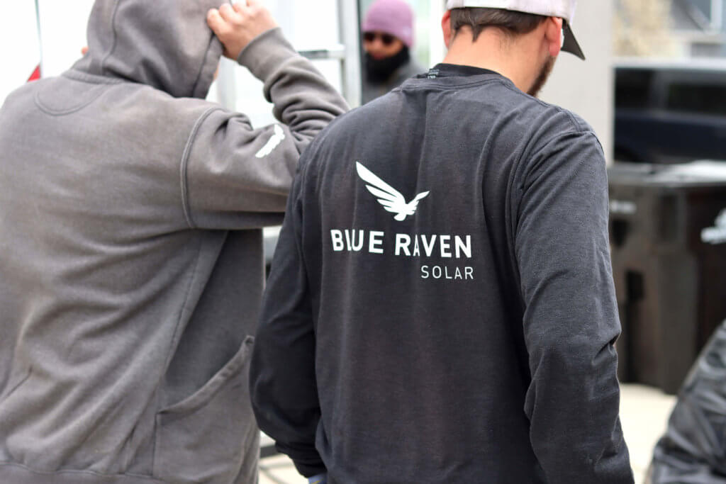 Two solar installers walking away in Blue Raven Solar branded apparel, after completing an install in Spanish Fork, Utah