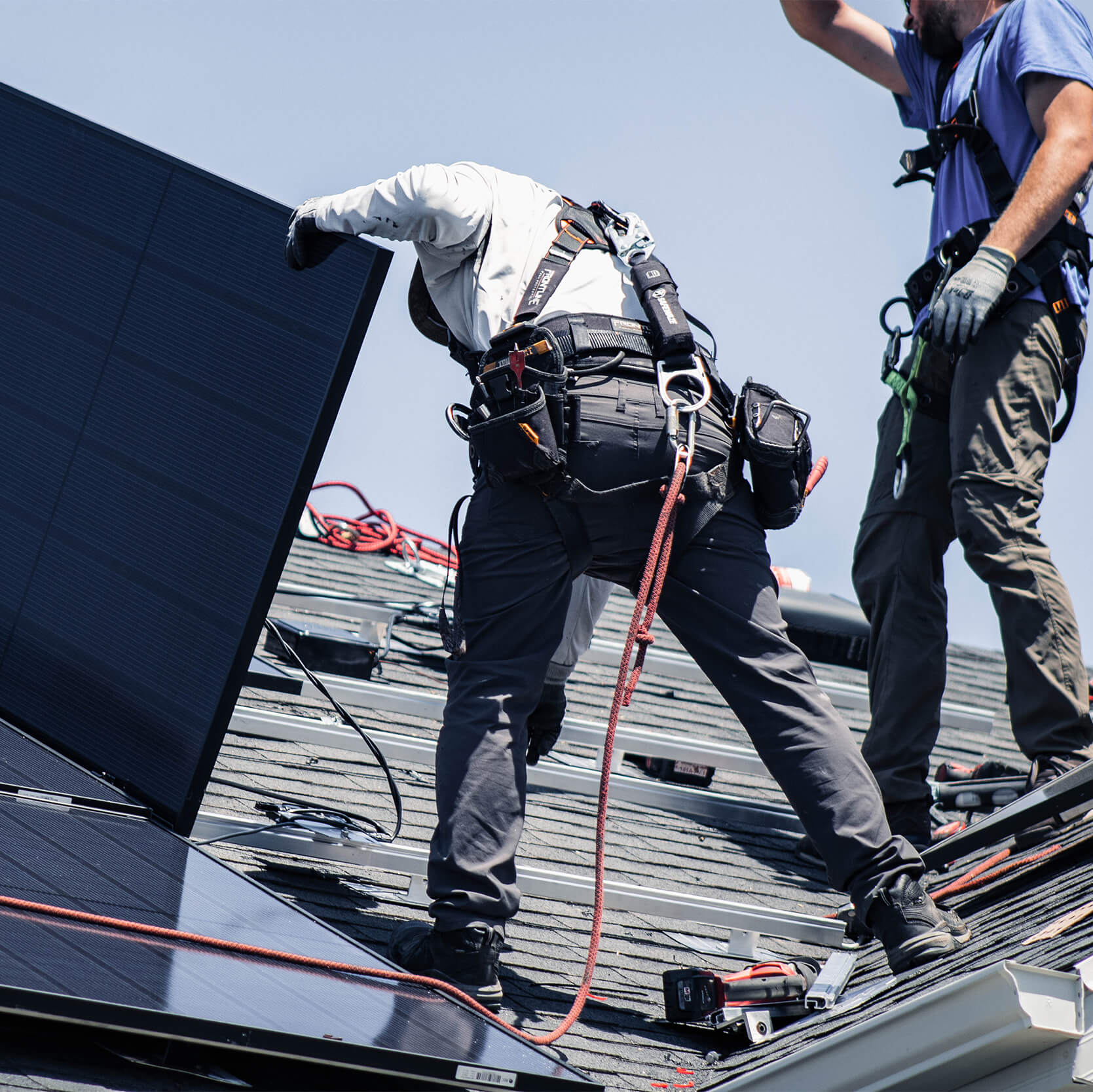 Two Blue Raven Solar installers laying out panels and connecting them to the racking system
