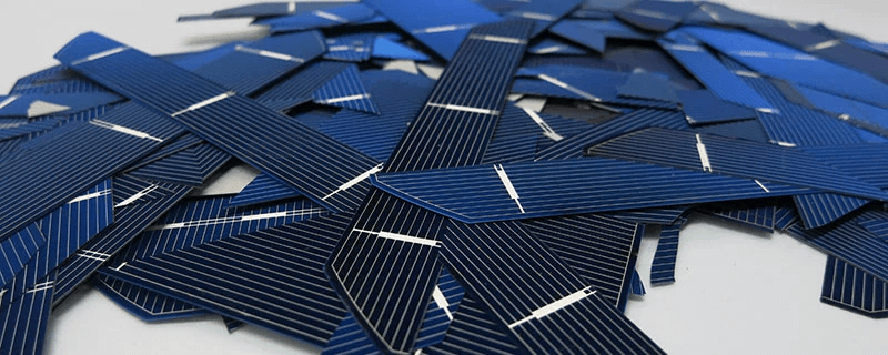 Various solar cells in a pile, some black and some blue in hue