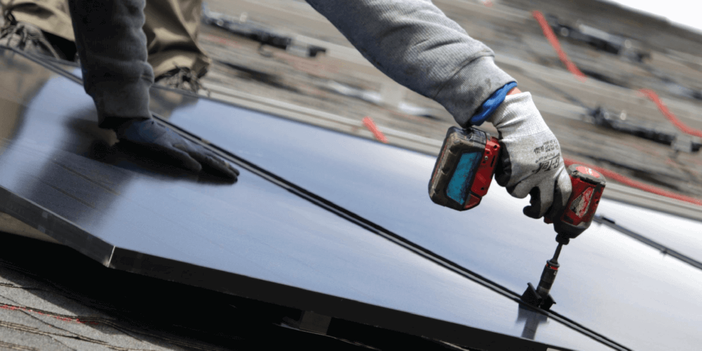 Solar panel installer securing a solar panel to the roof using specialized equipment