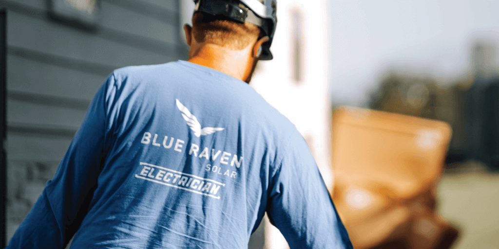 Male Blue Raven Solar electrician with a helmet on, preparing the electrical box for a solar installation