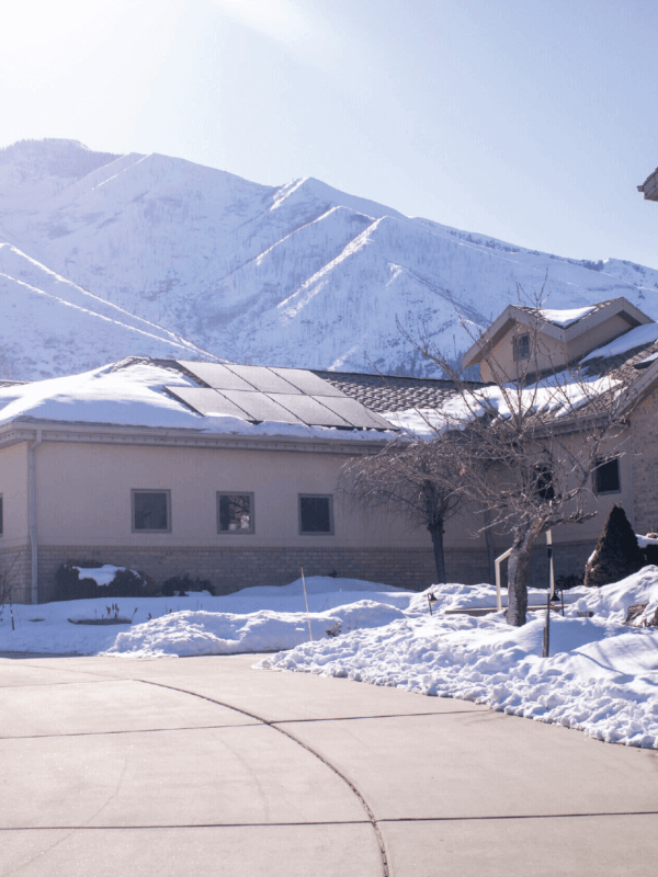 Large building structure with solar panel system installed with snow-covered mountain in the background
