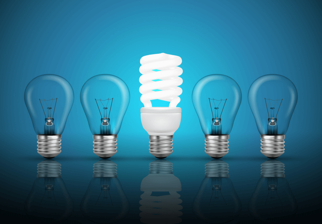 Five light bulbs in a row with one LED shining in the middle on a blue background