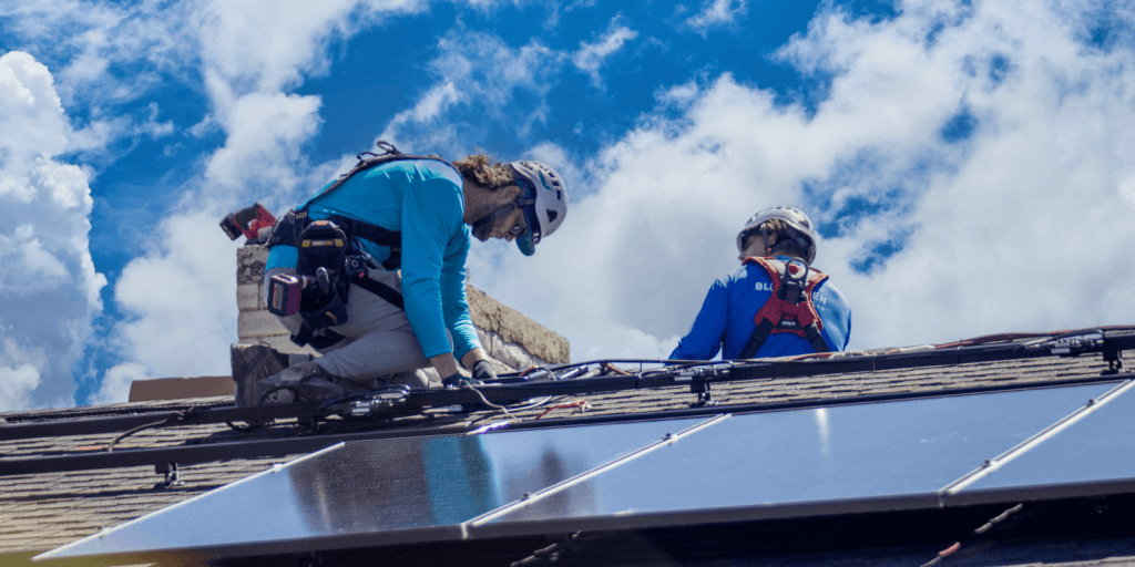 What is a Solar Power Production Guarantee-04 Two Blue Raven Solar installers on a roof, placing the racking for a customized, rooftop solar panel system