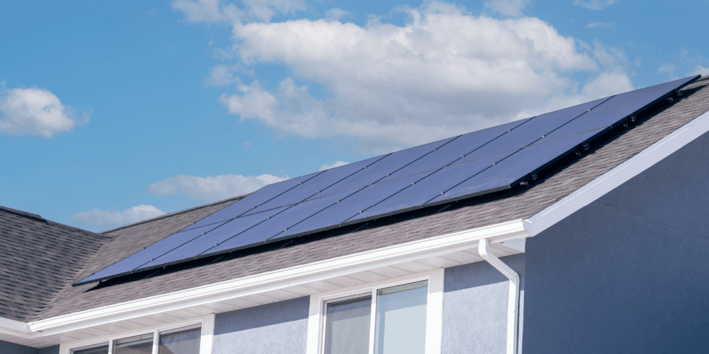 What is a Solar Power Production Guarantee-05 12-panel solar installation on a pale blue stucco house