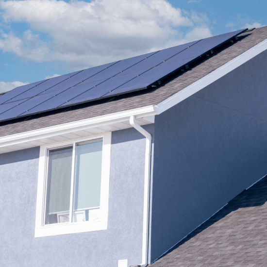 12-panel solar installation on a pale blue stucco house