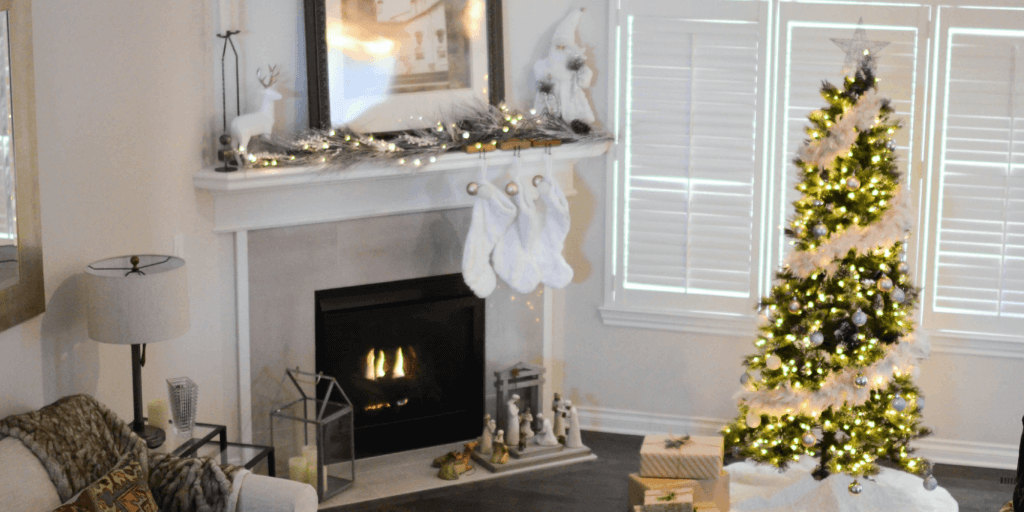 Neutral living room during the holidays with stocking handing by the fireplace, Christmas tree decorated